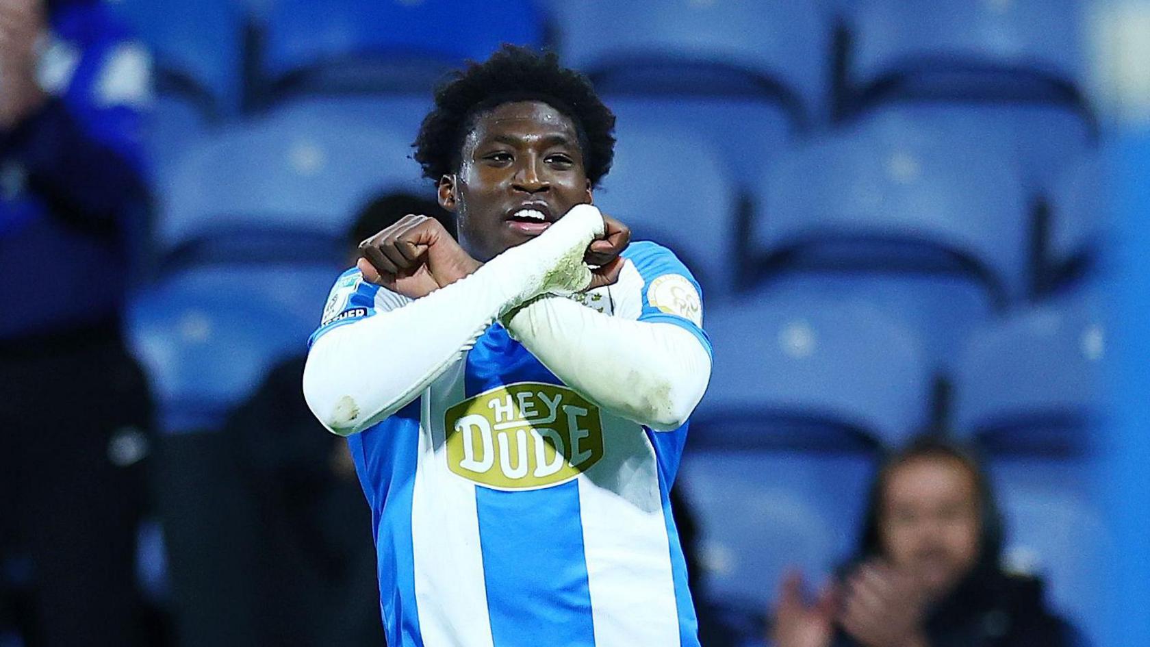Goalscorer Cameron Ashia celebrates scoring Huddersfield Town's third goal in their 3-0 win over Rotherham United by crossing his arms in front of his chest.