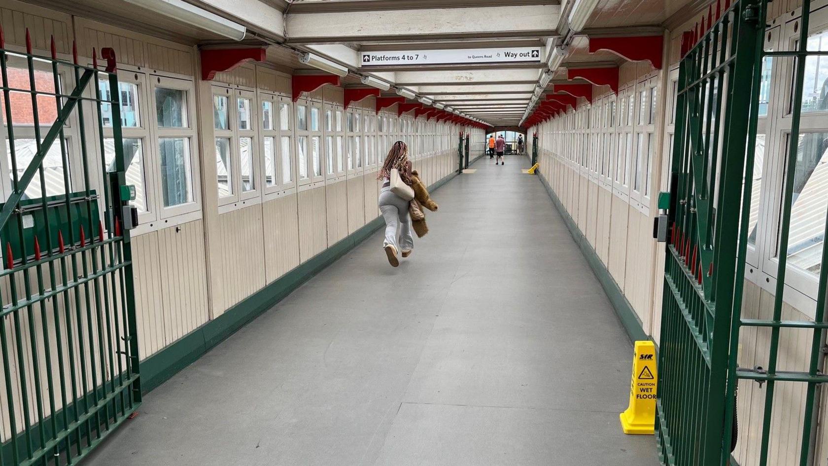 Looking down the length of the bridge, with a woman running away from the camera