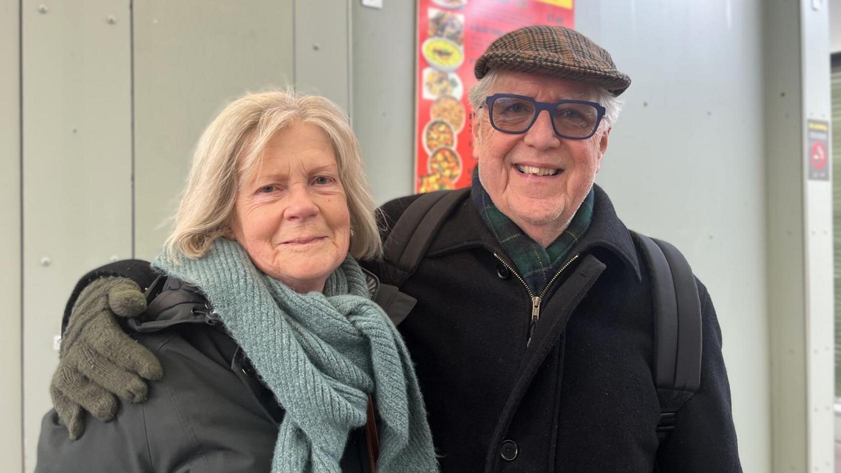 Duncan and Joan MacInnes smiling. Joan is wearing a thick scarf and Duncan is wearing glasses and a flat cap