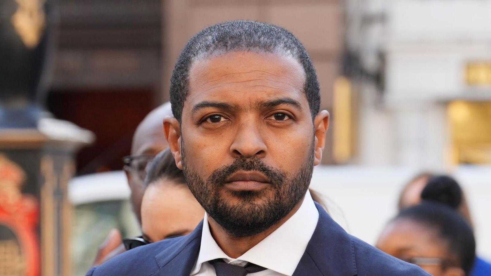 Noel Clarke arriving at the High Court on Friday 7 March, 2025. He is wearing a navy suit.