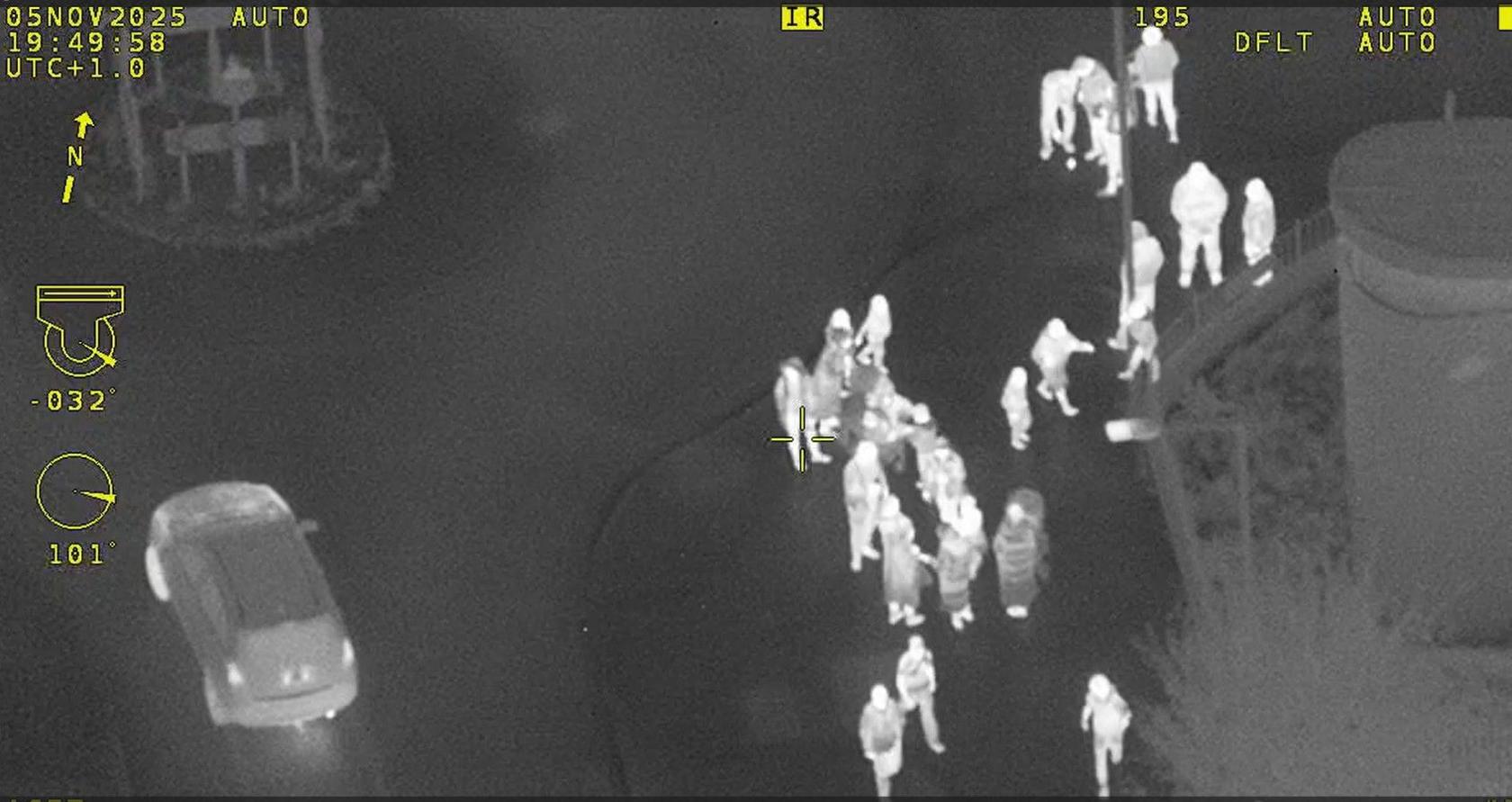 A group of people by a small roundabout, filmed from a police helicopter