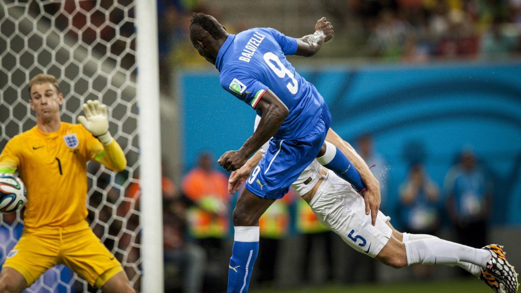 Italian striker Mario Balotelli heads the ball to score against England