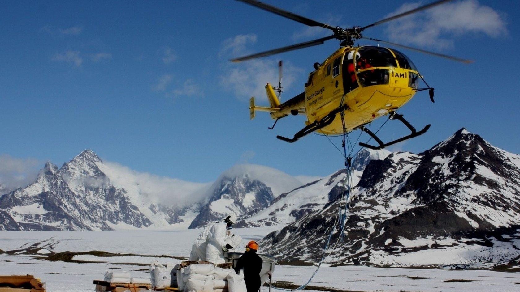 Helicopter spreading rat bait on South Georgia