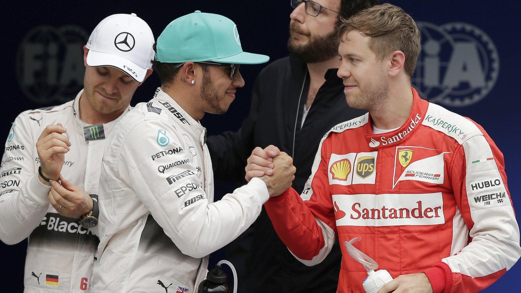 Lewis Hamilton shakes hands with Sebastian Vettel as Nico Rosberg waits to congratulate the German
