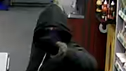 Photo from shop CCTV from a shop in Tuffley in Gloucester showing a robbery suspect dressed in dark clothes and with a dark hood