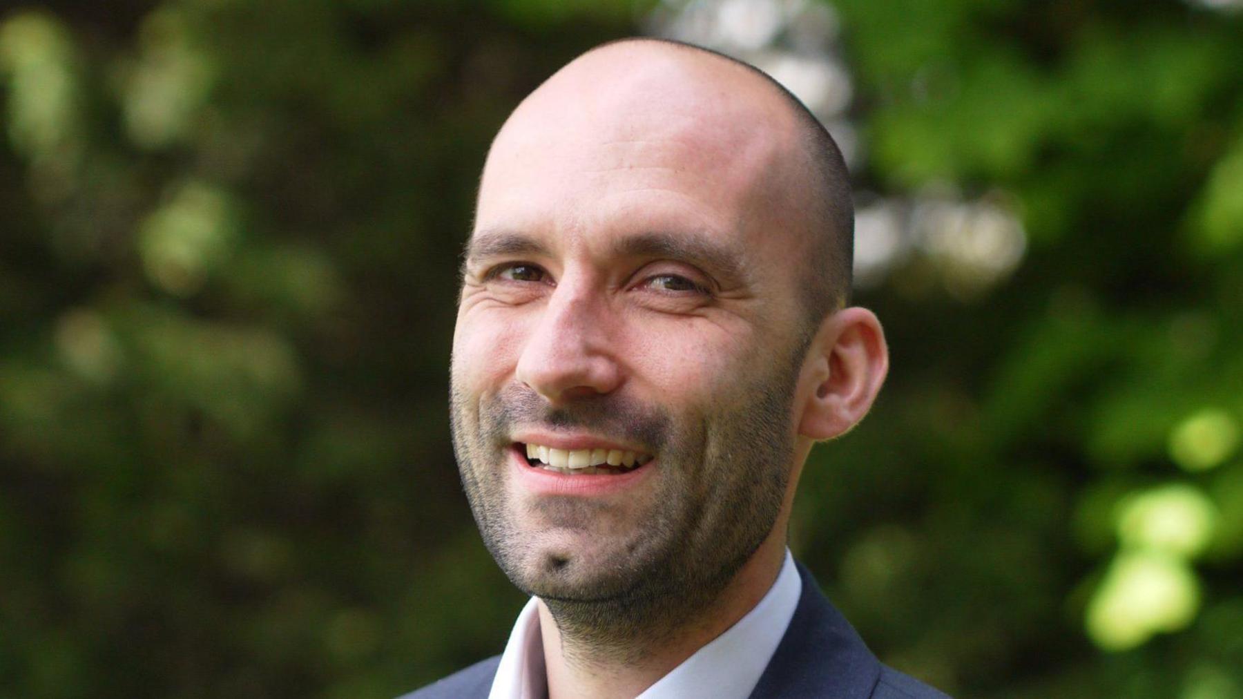 Tom Nutt is balding with close-cropped hair and stubble