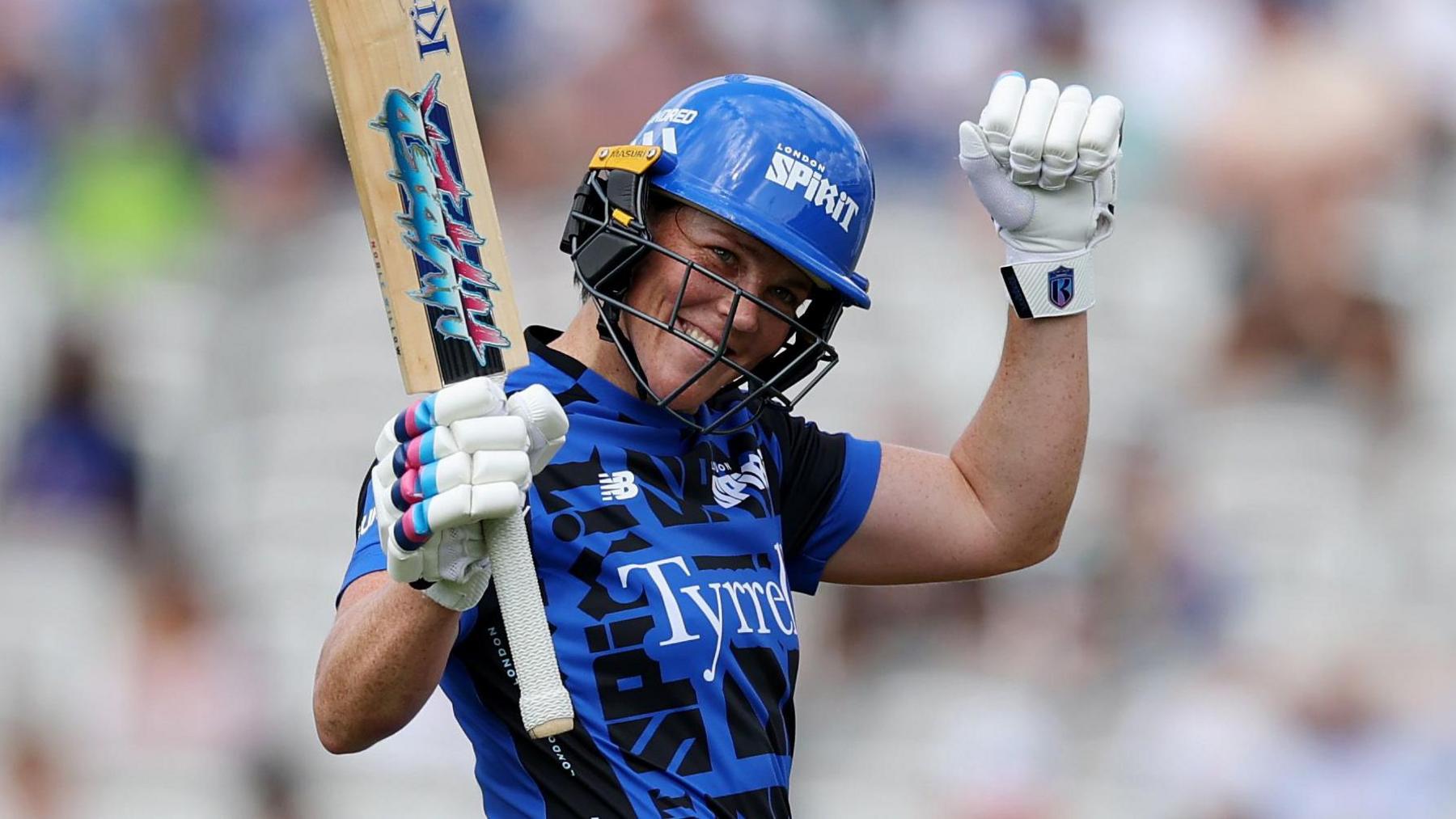 Grace Harris raises her bat after reaching her half-century for London Spirit against Oval Invincibles at Lord's