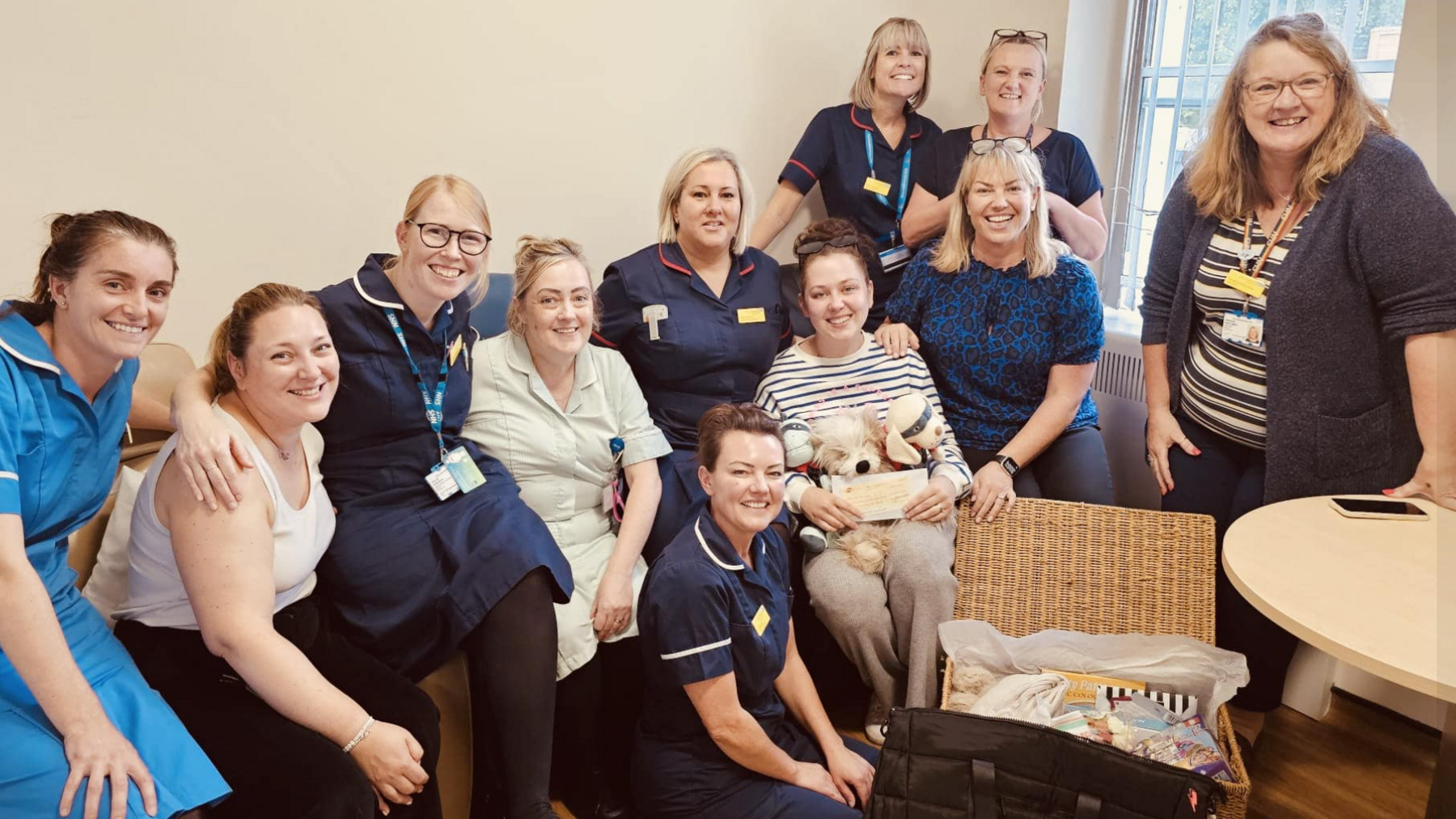 Group photograph of maternity staff wearing uniforms with Jenni Hayes picture in the centre