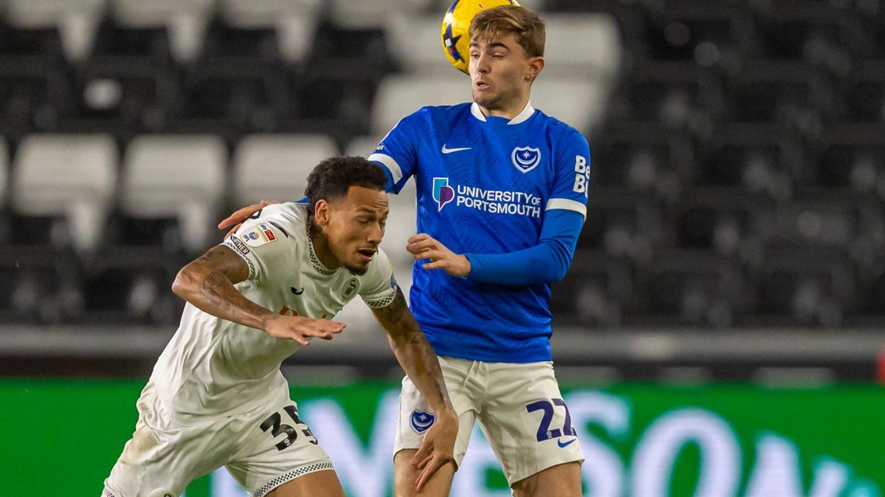 Portsmouth FC defender Zak Swanson (22) competes for a high ball with Swansea City FC's attacker Ronald Pereira Martin (35)