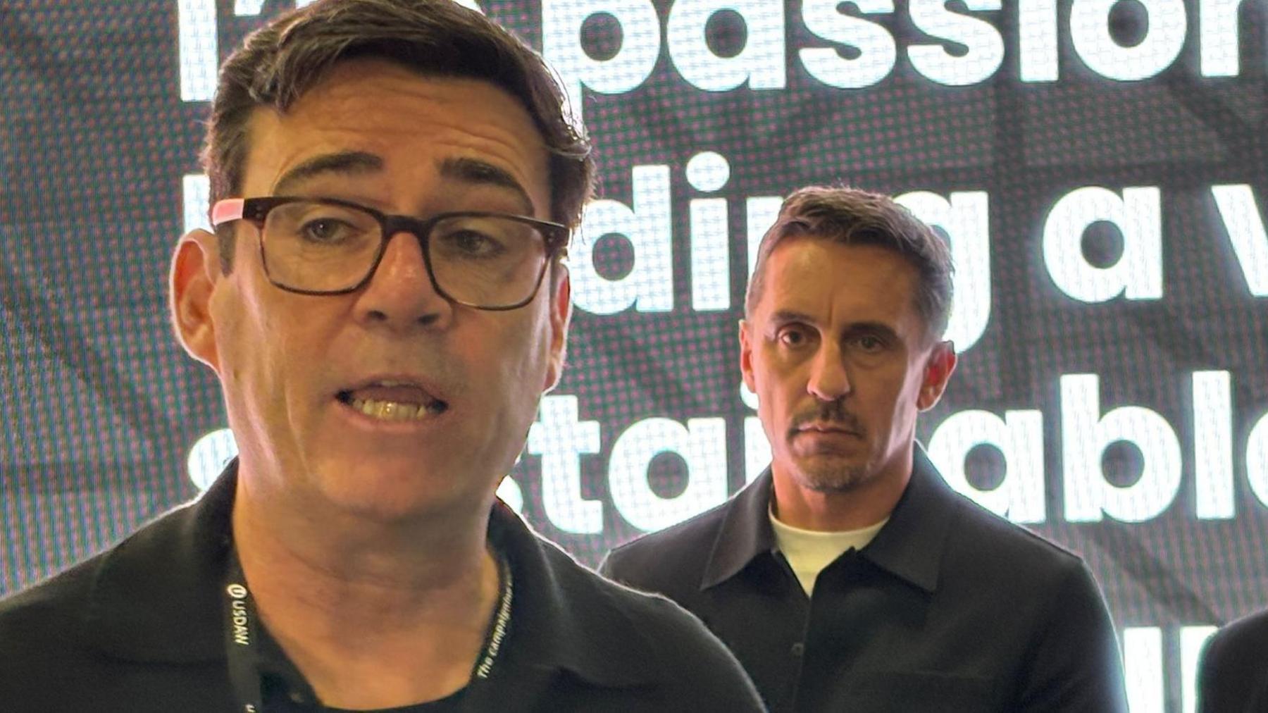 Greater Manchester mayor Andy Burnham speaking at the Labour conference as football star Gary Neville stands behind him 