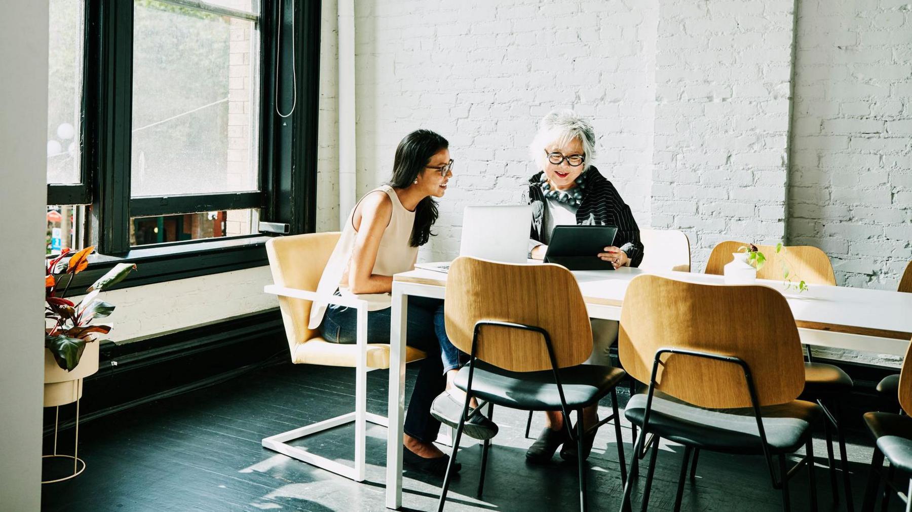 two women hold a meeting in a boardroom