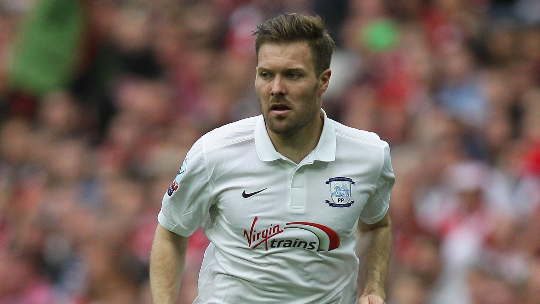 Scott Laird running on the pitch with the ball at his feet while playing for Preston in 2015