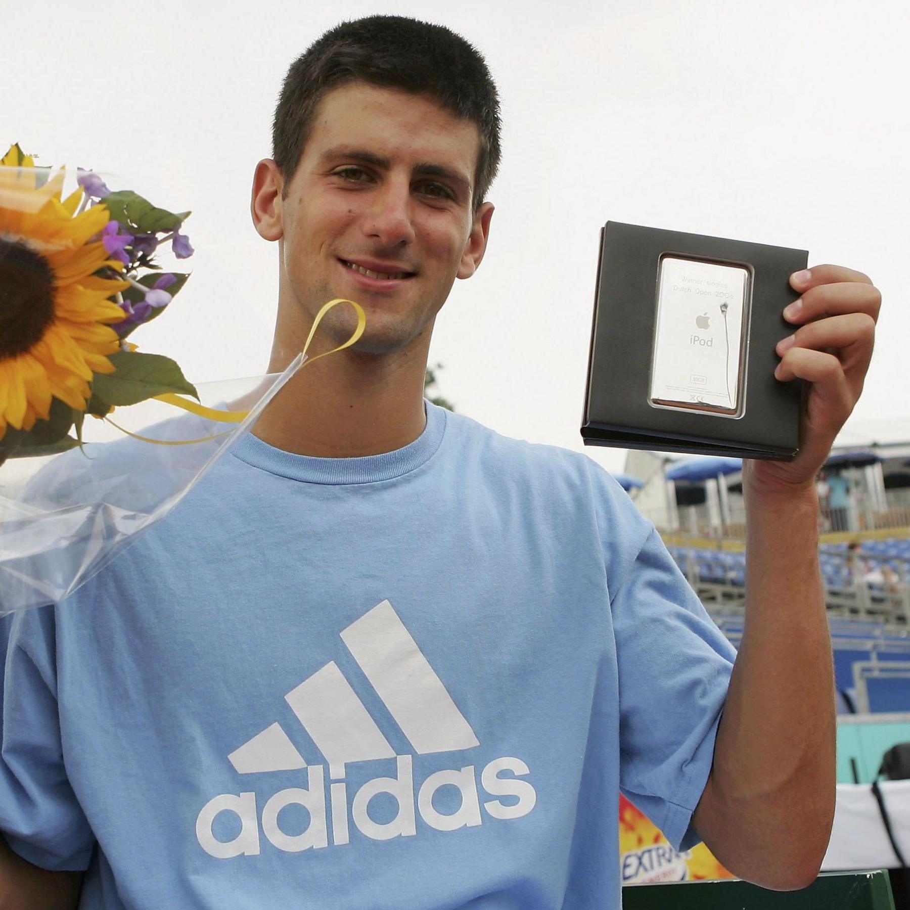 Novak Djokovic holds aloft his prizes for winning the Dutch Open in July 2006