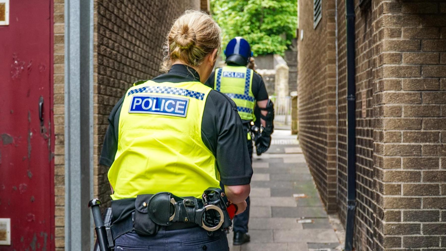 Police officers going down an alleyway