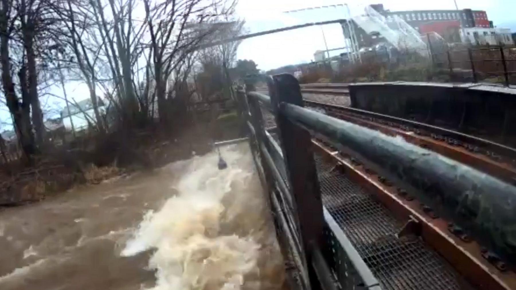 Water rising close to the train track over a river