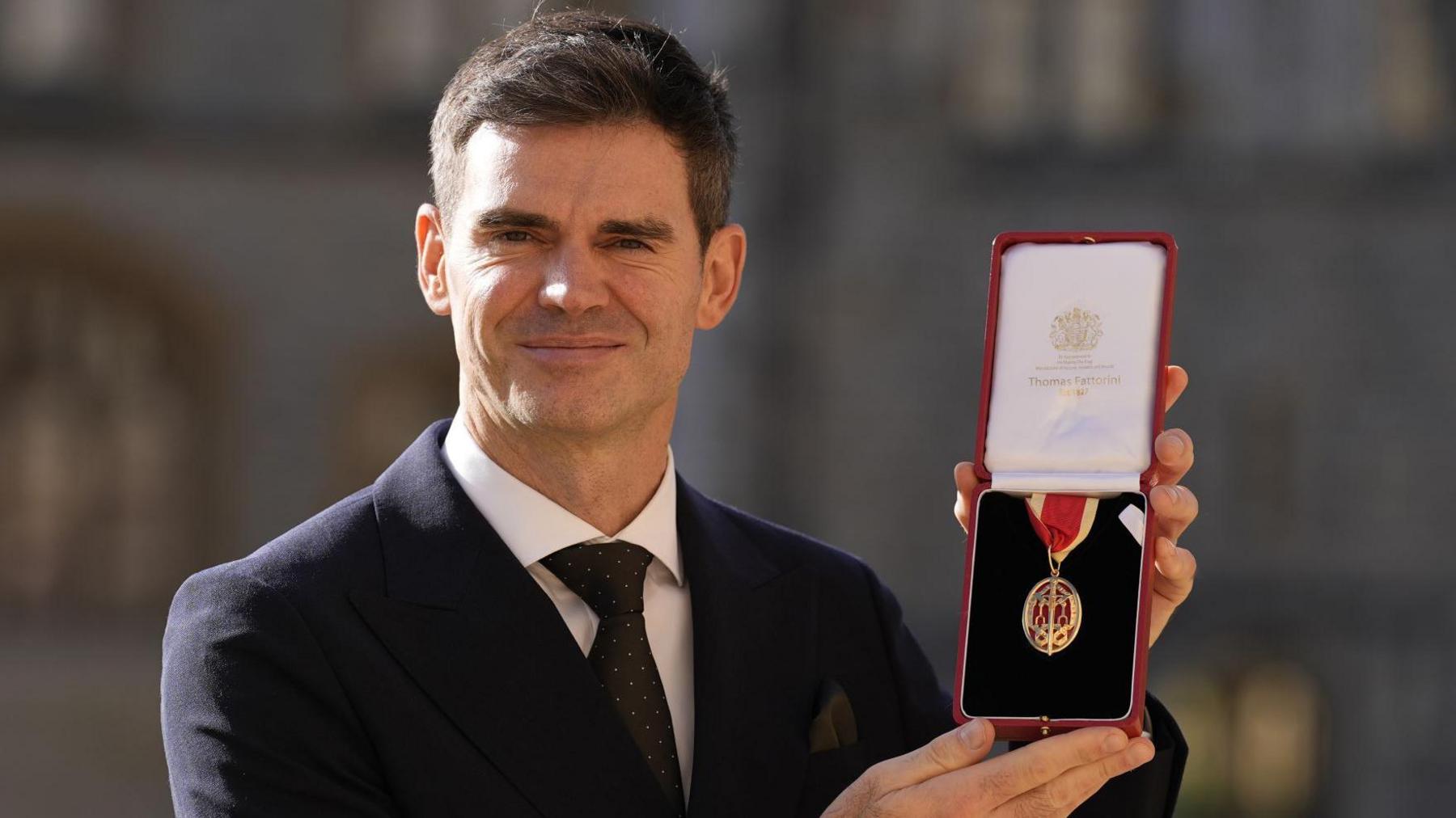 England bowler James Anderson poses after being awarded a knighthood