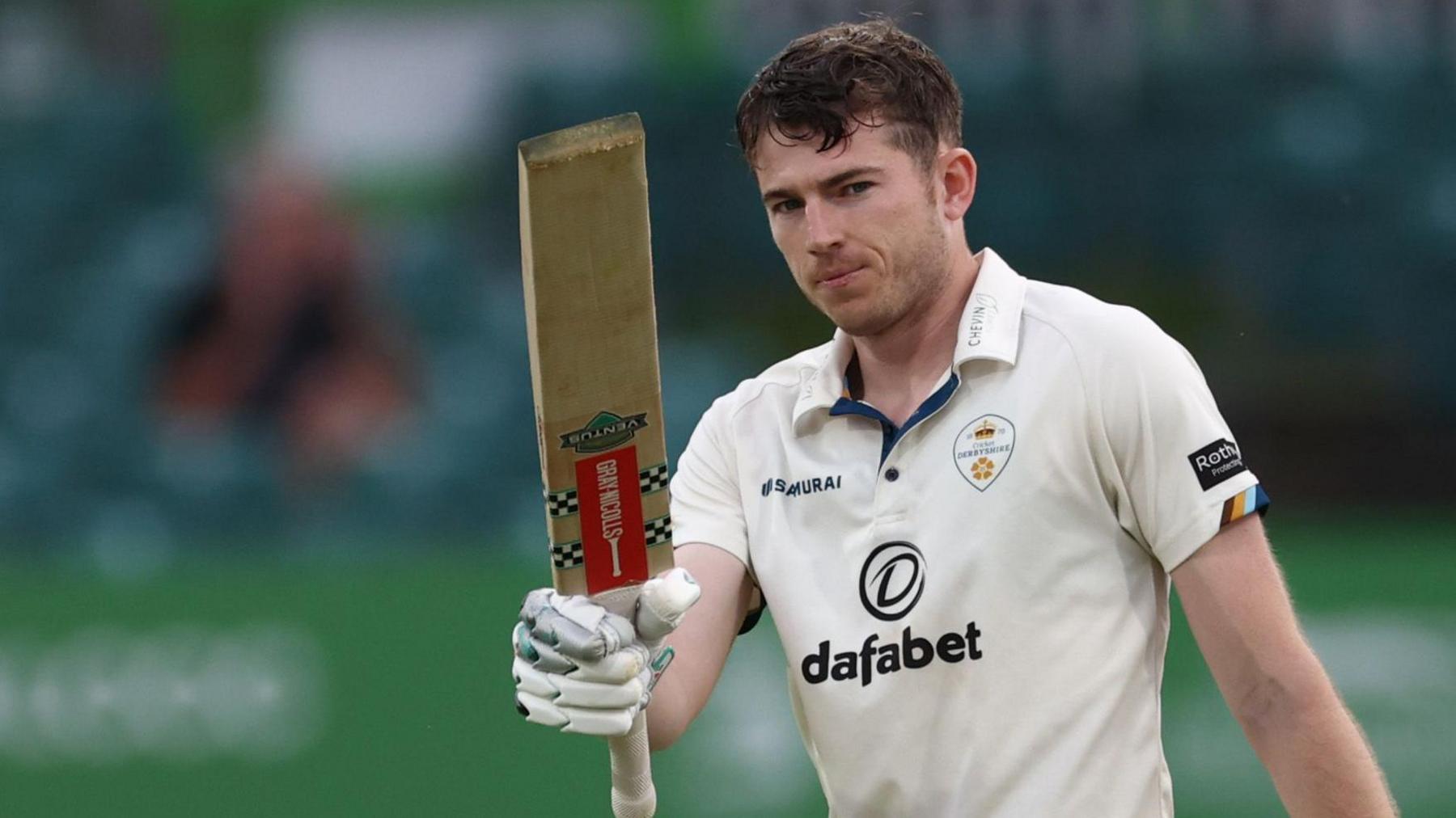 Derbyshire's Martin Andersson holds his bat up after scoring a century against Leicestershire