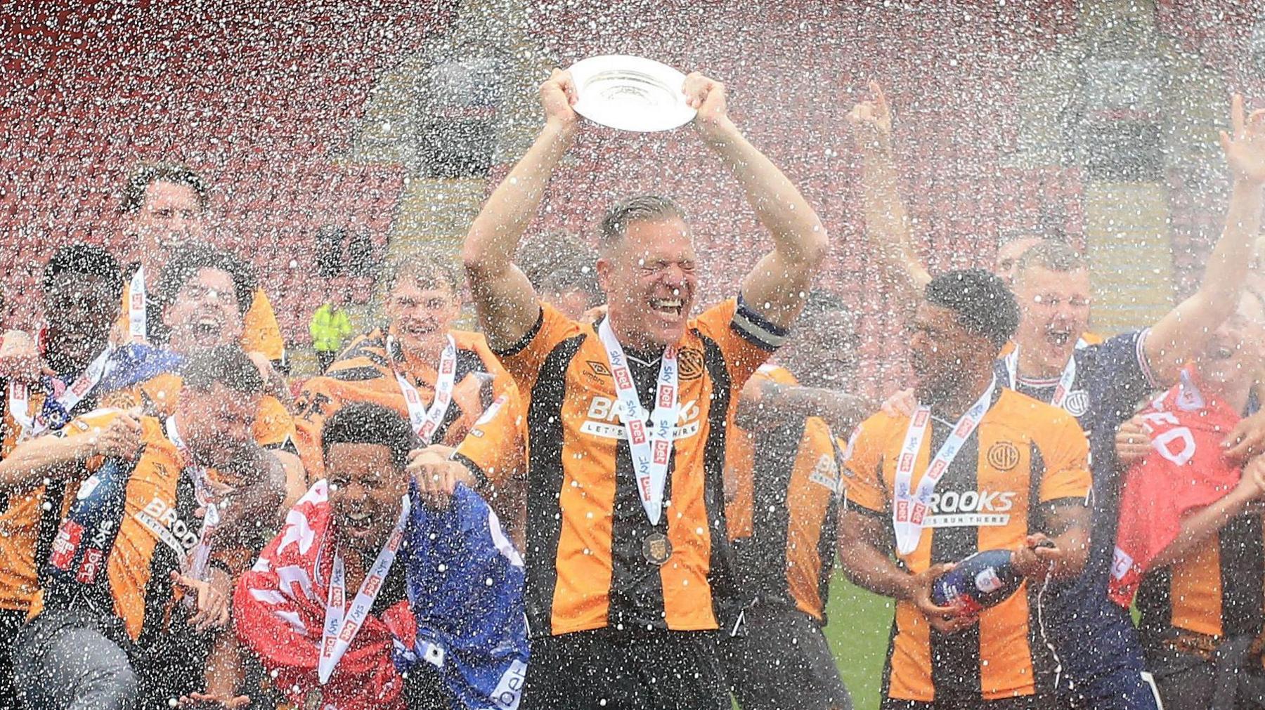 Cambridge United captain Michael Morrison lifts the League Two trophy 