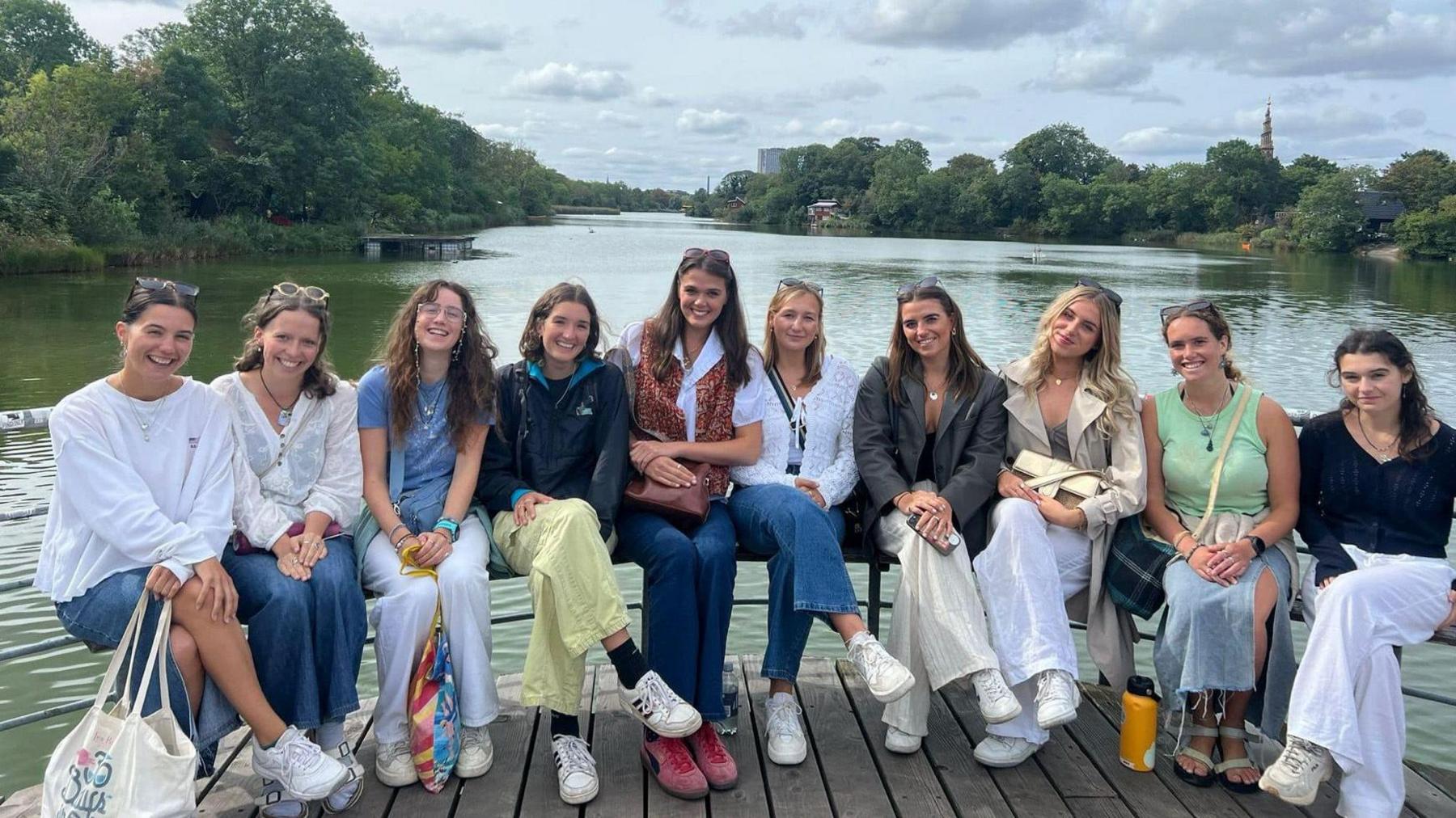 Lois Vidamour, Hannah Langlois, Emily Savident, Alex Oliver, Suzannah Tostevin, Sophie De La Mare, Orla Rabey, Abi Tardivel, Jenny Thomas and Hannah Vidamour (left to right) sat riverside in Copenhagen. 