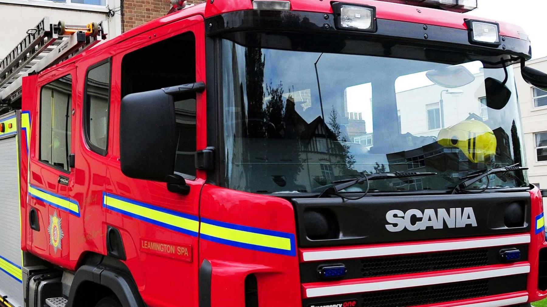 A generic image of a fire engine. The engine is red with a yellow and blue stripe and the make of the vehicle which is 'Scania' is at the front. 