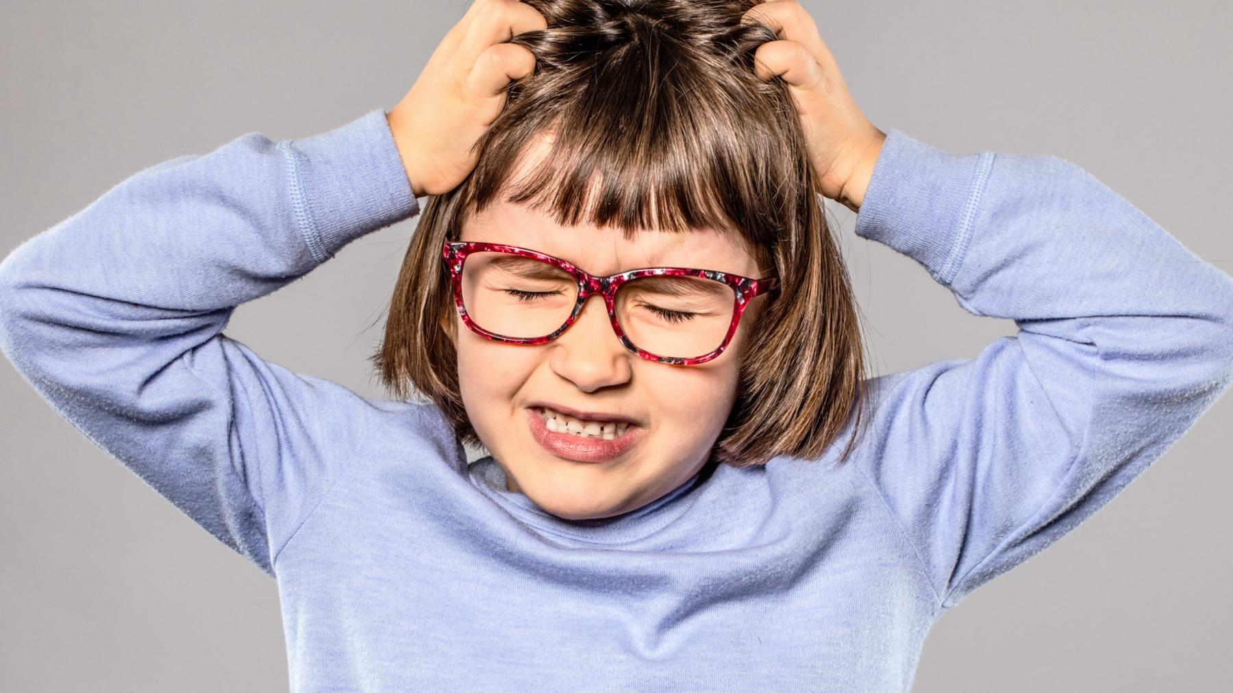 Girl with hands on her head.