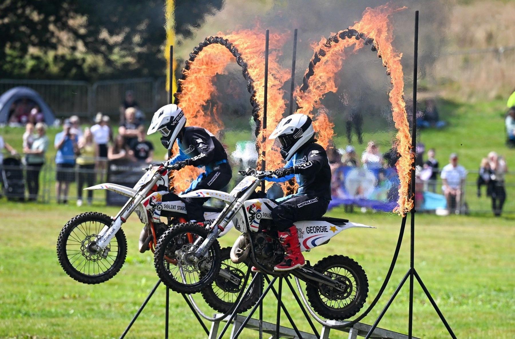 Two motorcyclist jump through flaming hoops at the Bristol Balloon Fiesta 2024