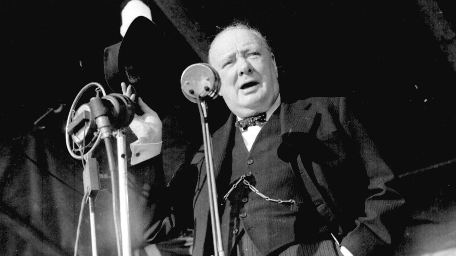 Prime Minister Winston Churchill addresses an audience of more 20,000 at Walthamstow Stadium, London on 4 July1945. He is standing behind several microphones but the audience is not pictured.