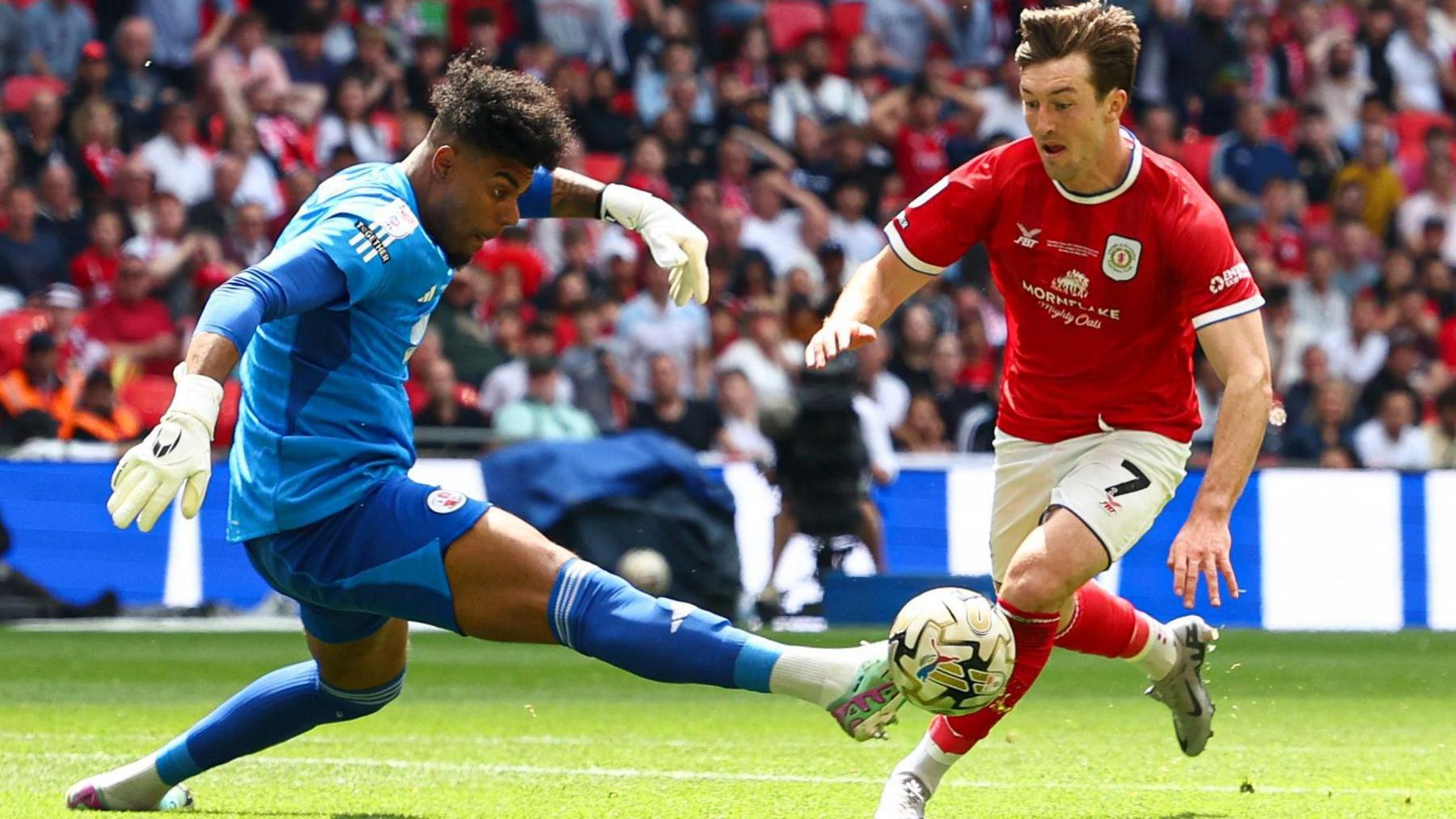 Chris Long goes down in the penalty area under a challenge with Crawley goalkeeper Corey Addai in the League Two play-off final at Wembley