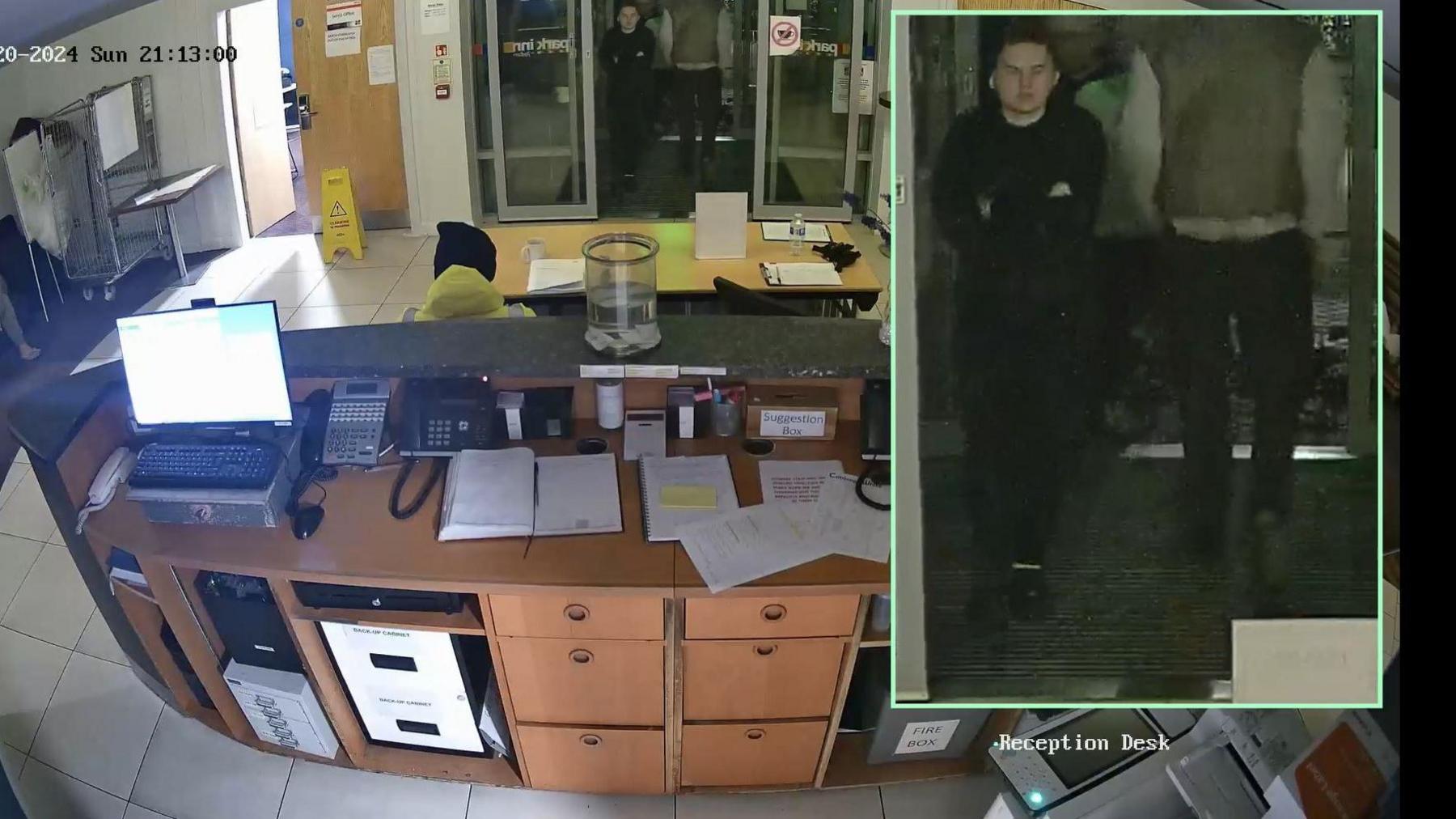 Colour CCTV shows the three workers walking back into the hotel and a man walking past them going in the opposite direction. A staff member is sitting at reception with their back to the camera.