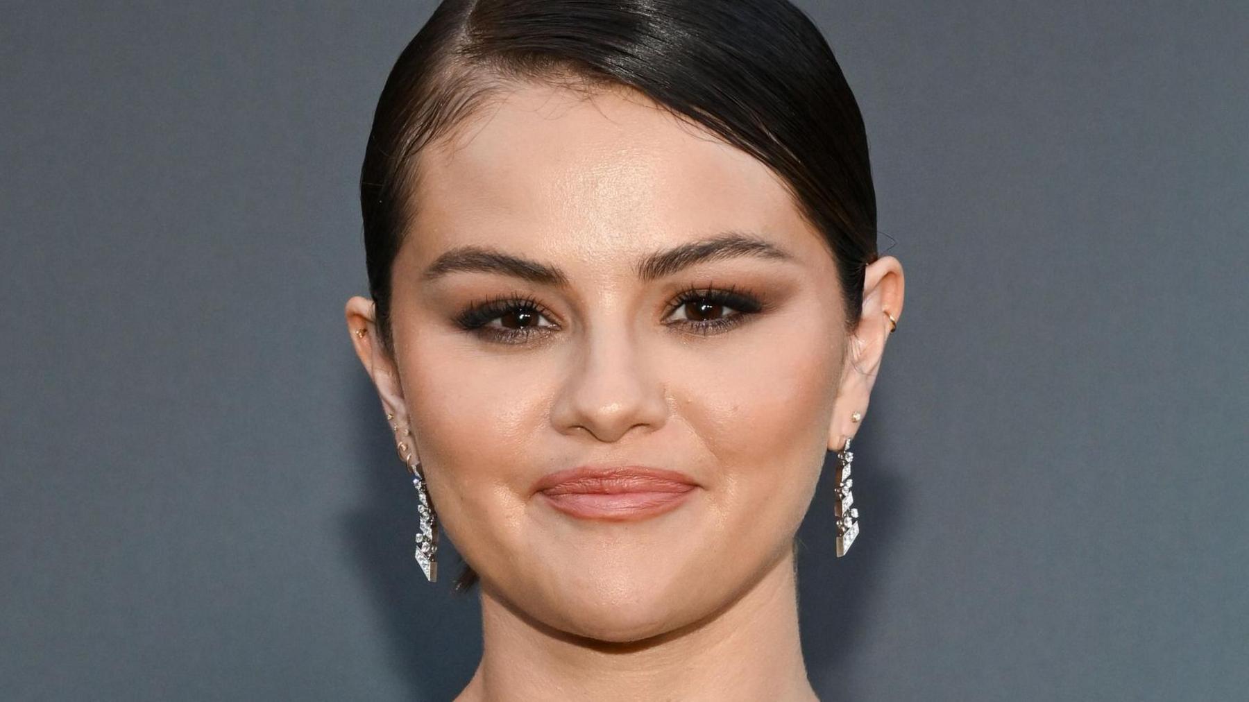 Selena Gomez head shot, wearing drop diamond earrings