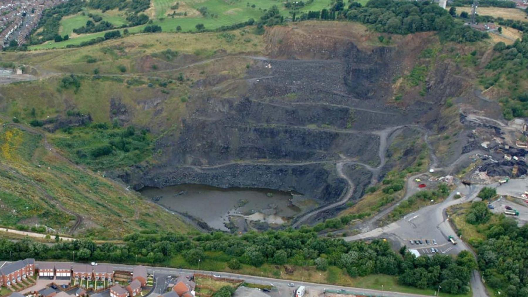 The former Edwin Richards Quarry in Rowley Regis. It is steep and has lots of sharp banks. There are some homes nearby and some fields. 