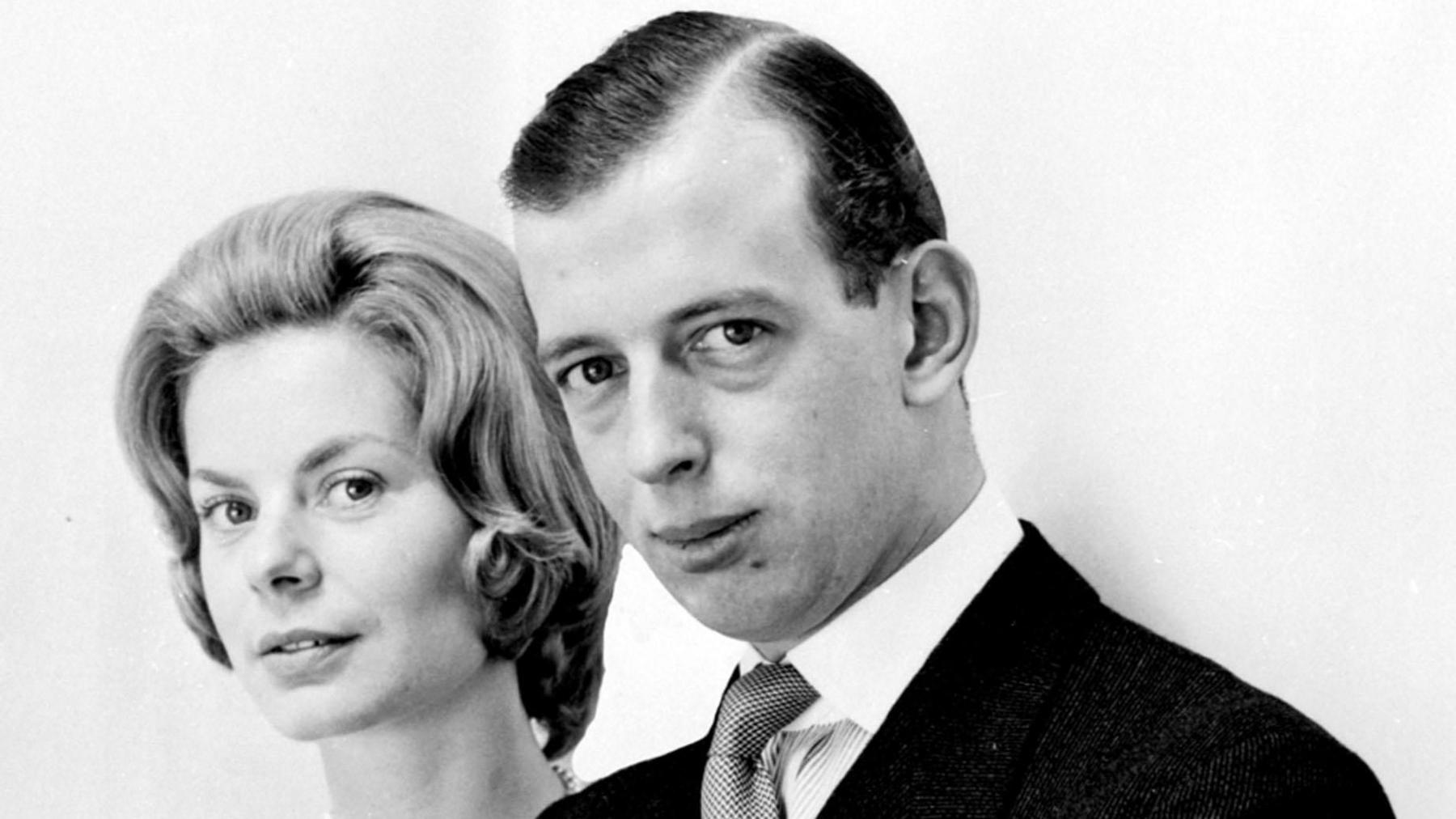 A black and white headshot of a young man and woman. They are looking at the camera, but their bodies are angled to one side. 