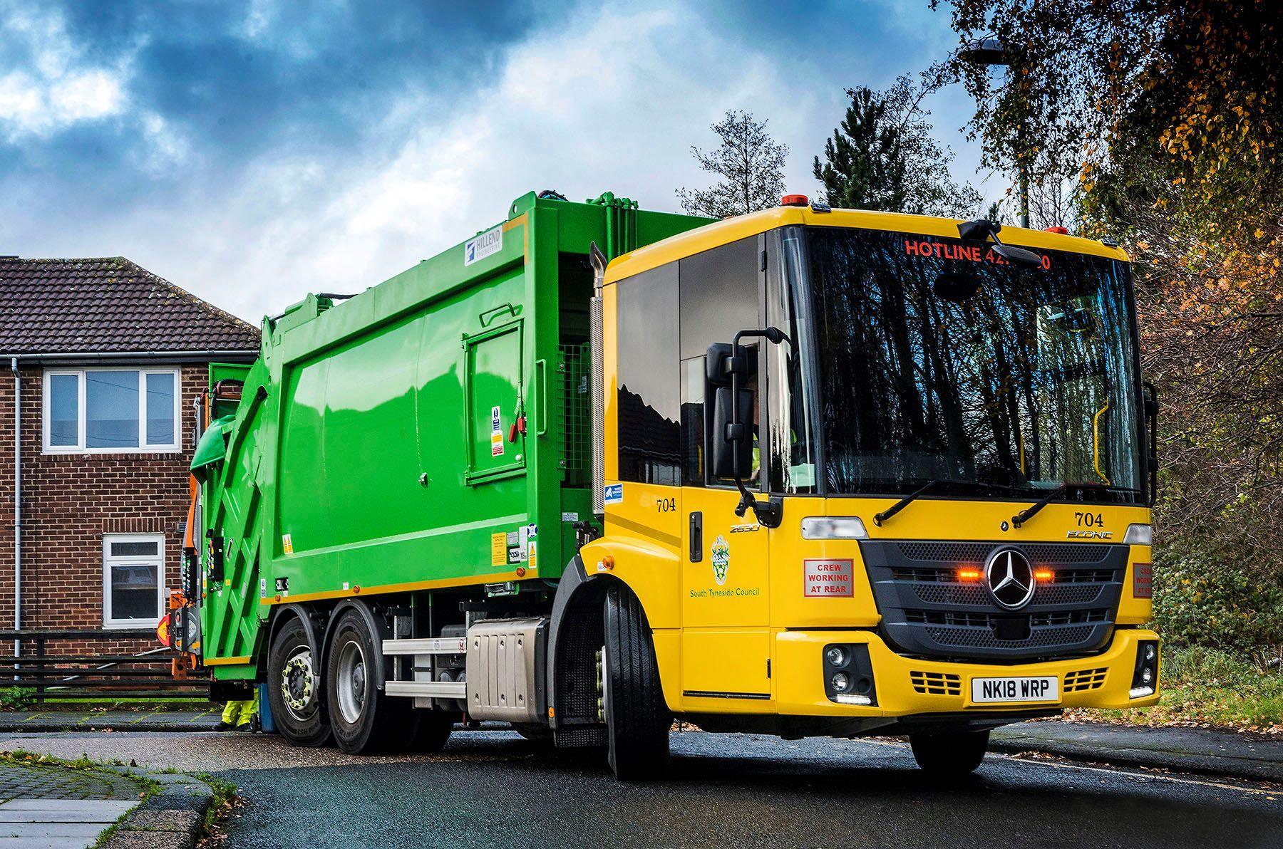 A green and yellow bin lorry. 