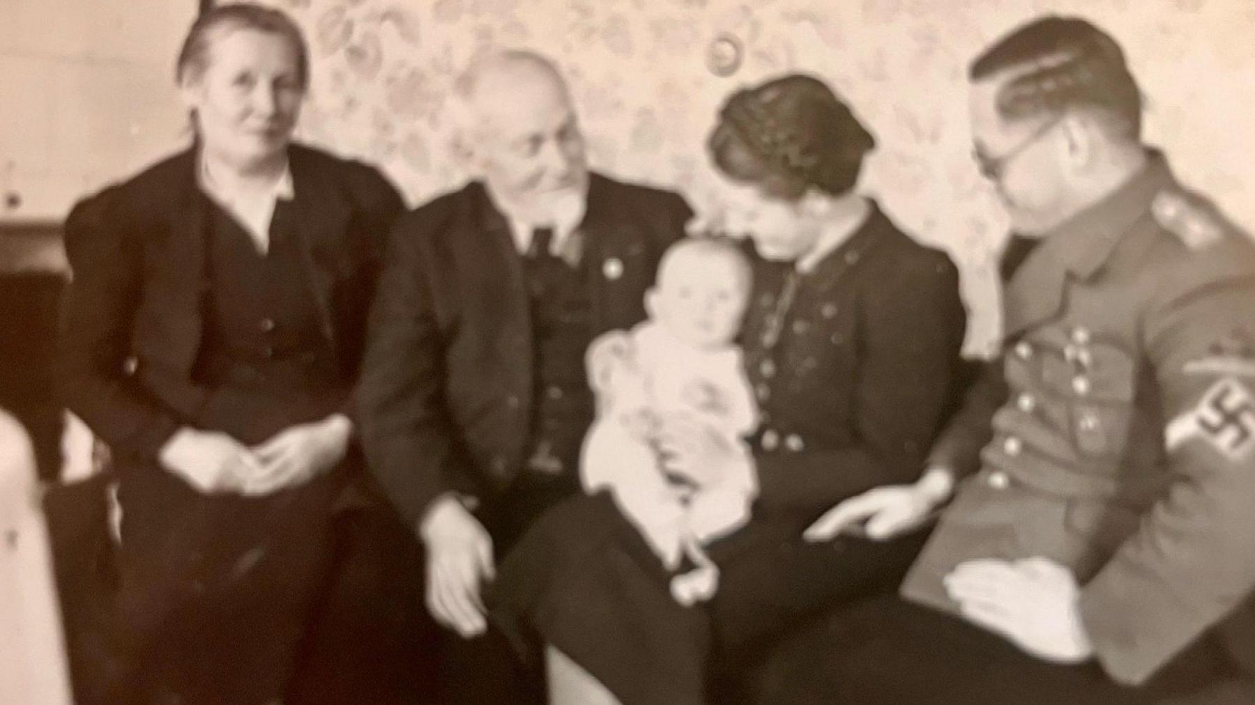 The newborn Peter with his mother's parents, her sister and brother-in-law in uniform and wearing a swastika armband.