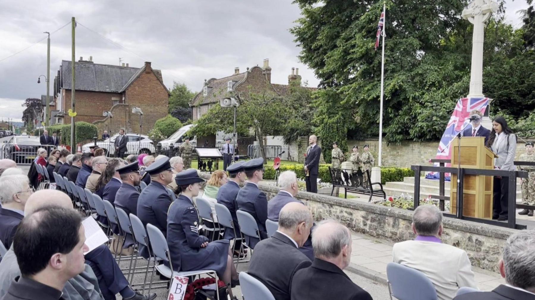 Audience sitting watching speakers at war memorial