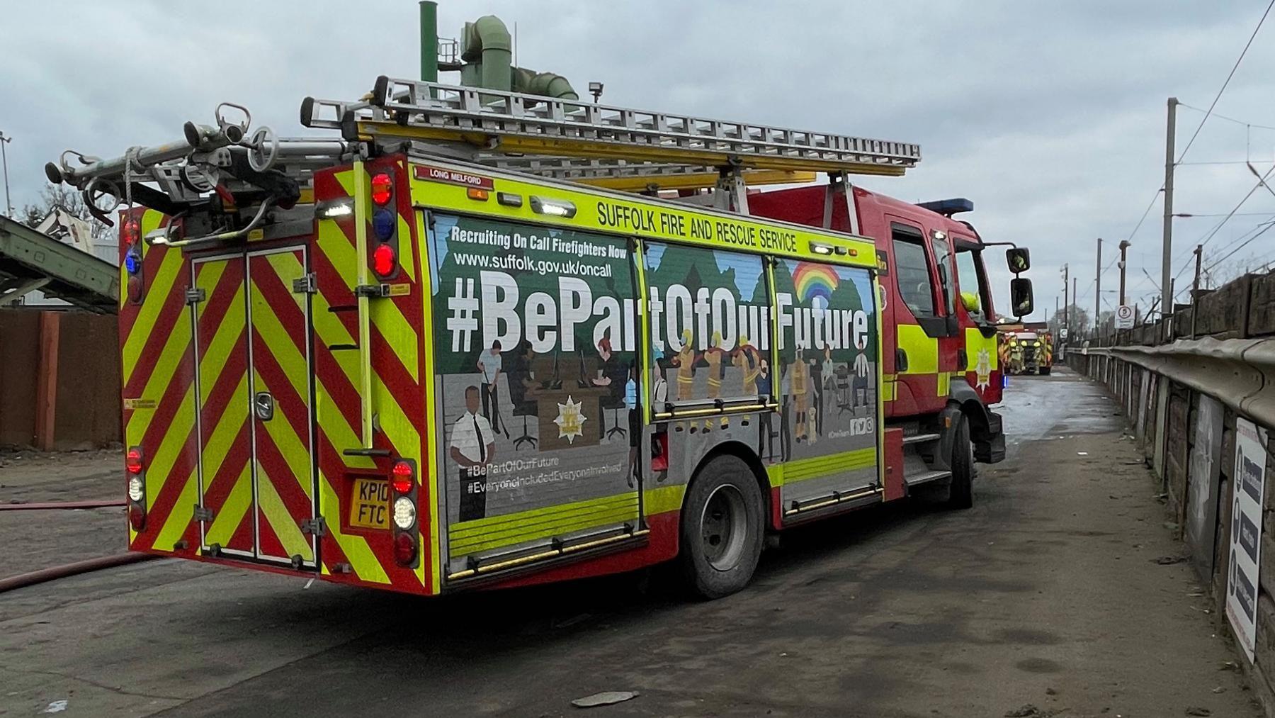 A Suffolk Fire and Rescue Service fire engine on a road, the rear of the vehicle is pointing towards the camera.