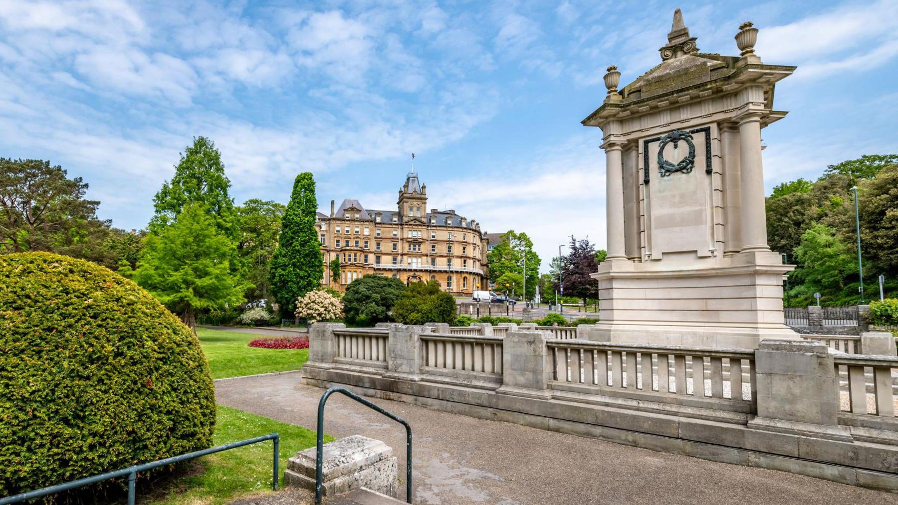 Bournemouth war memorial, a white stone monument set in a park. In the background is the town hall.