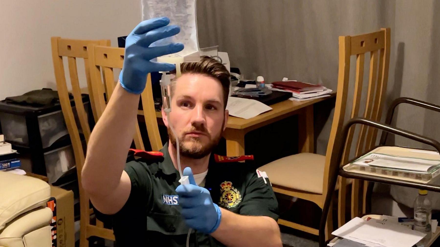 Paramedic sets up intravenous drip