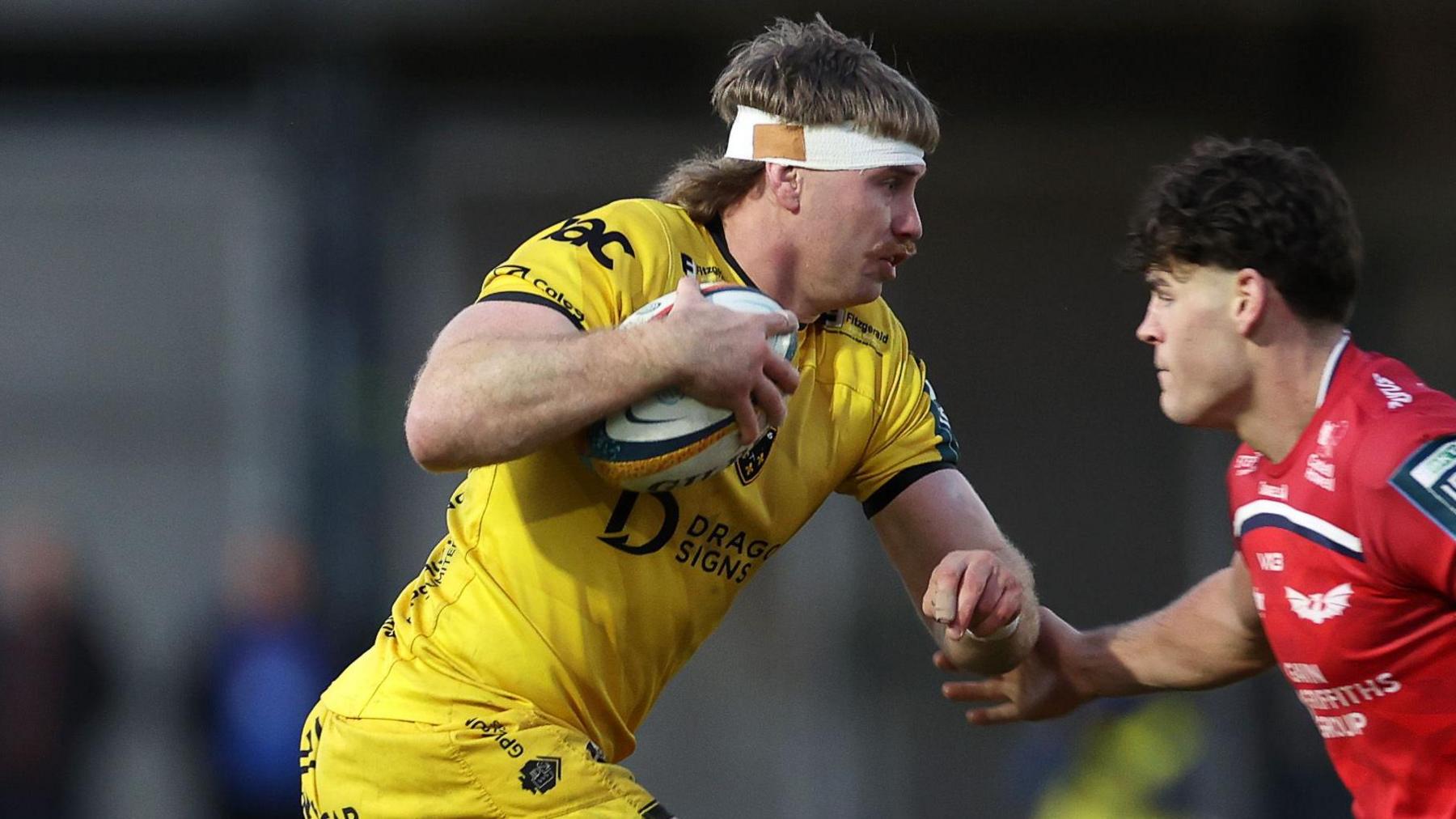 Dragons number eight Aaron Wainwright runs with the ball against Scarlets