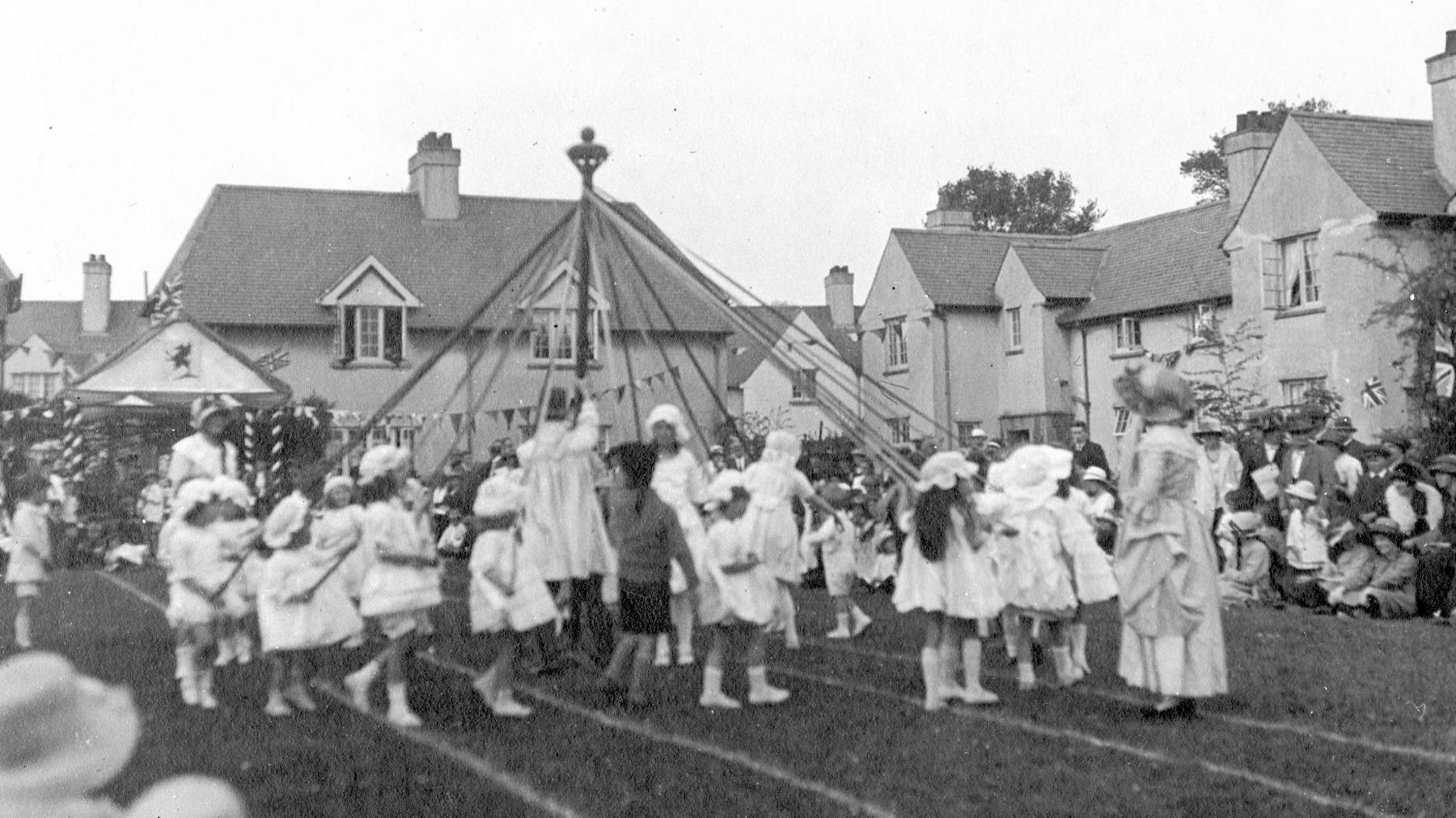 Ffotograff o blant yn dawnsio o amgylch polyn Mai yn Rhiwbeina
