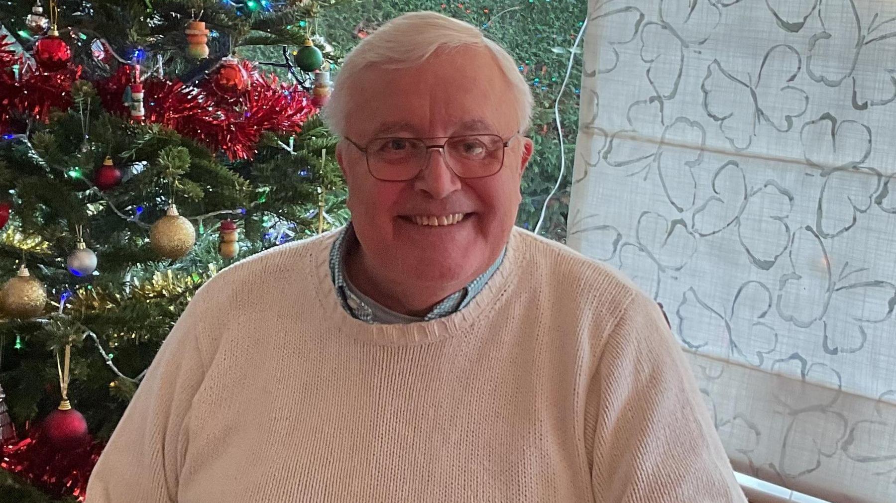 Gary Pearson at home in front of a Christmas tree