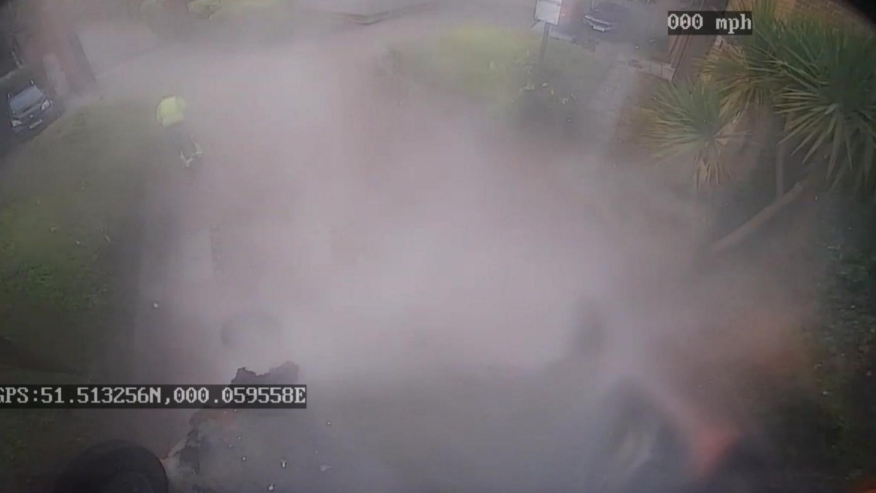 Image from CCTV footage showing smoke surrounding upside down bin 