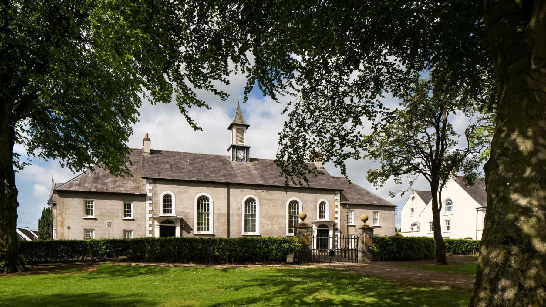 Gracehill moravian church, a grey building which has been photographed through some trees