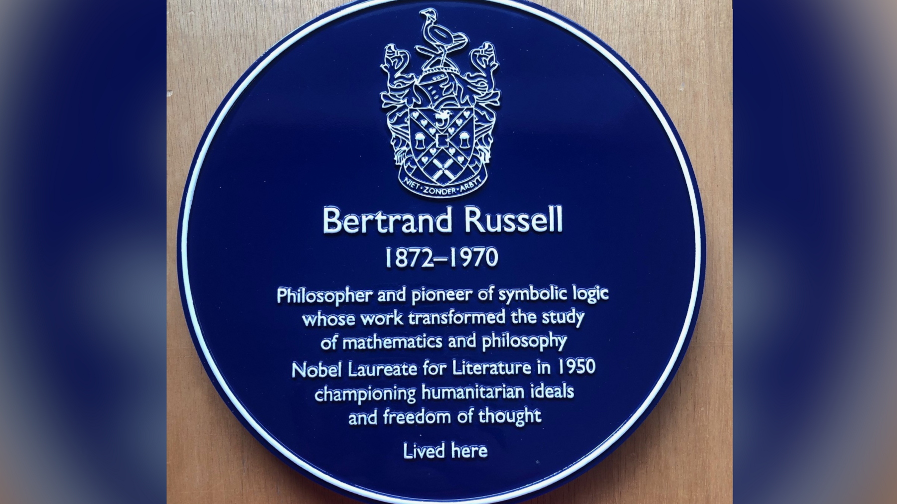 A blue plaque is circular and has writing on it. It reads: "Bertrand Russell 1872-1970. Philosopher and pioneer of symbolic logic whose work transformed the study of mathematics and philosophy. Nobel Laureate for Literature in 1950 championing humanitarian ideals and freedom of thought. Lived here"