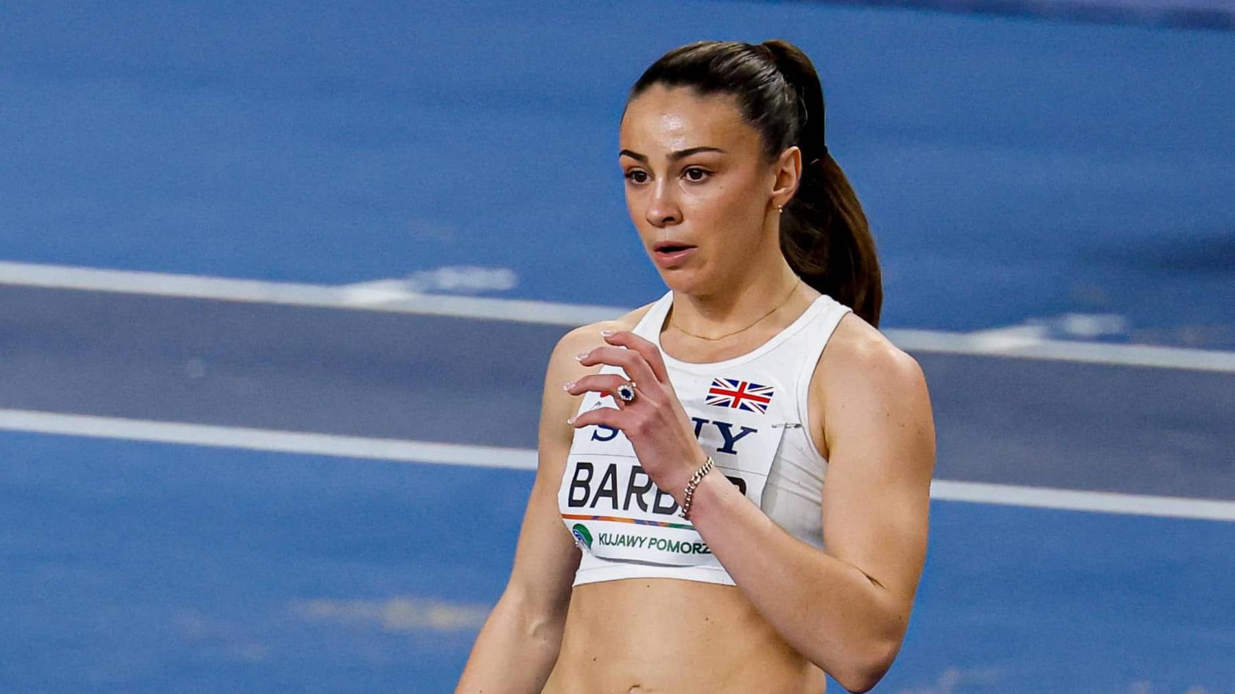 Ellen Barber standing with her left arm bent towards her chest on the track at the 2025 World Athletics Indoor Championships as she prepares to compete in the high jump