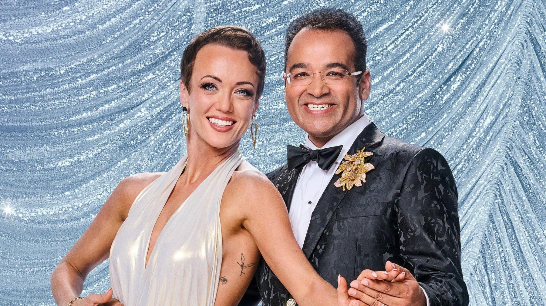 The picture shows Lauren Oakley and Krishnan Guru-Murthy posing in front of a sparkly background.