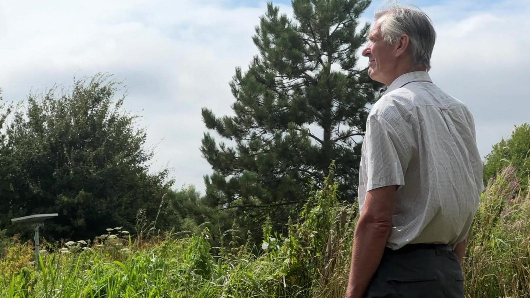 Richard Shackleton looks out at the countryside from the edge of a canal (out of shot)