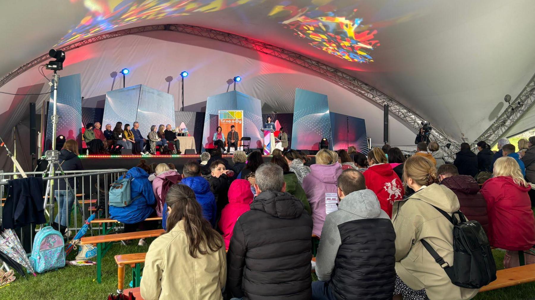 Cynulleidfa yn gwrando ar restr fer Tir na nOg