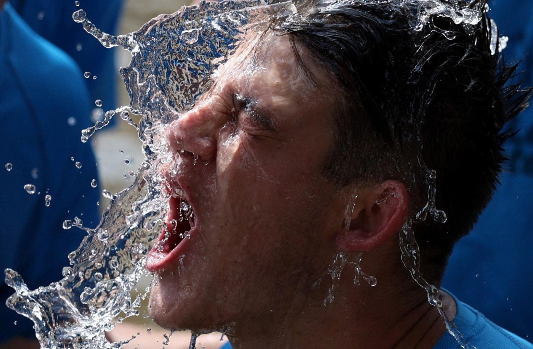 A football player is splashed with water in the face during the annual river match in Bourton on the Water in Gloucestershire