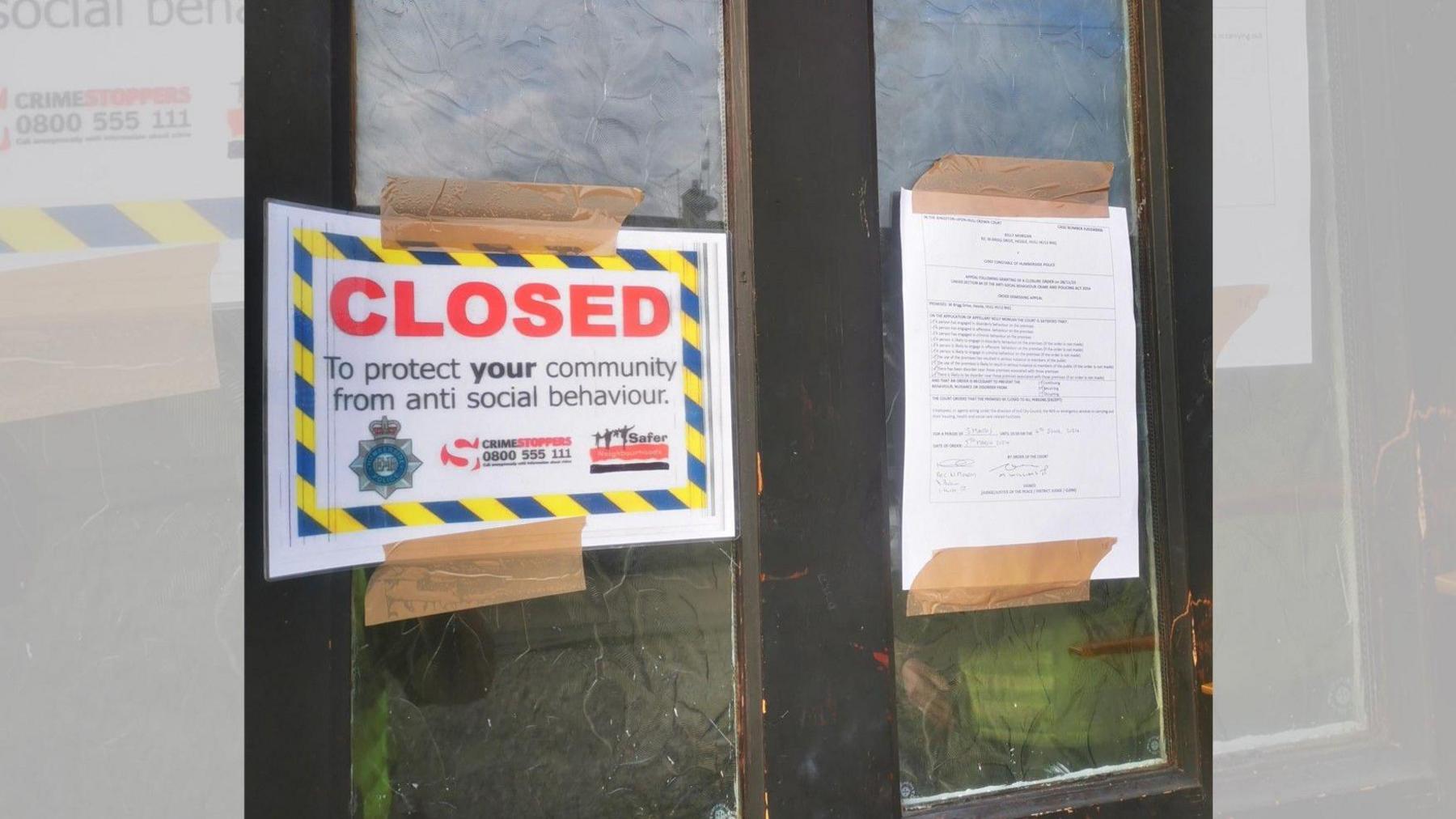 Antisocial behaviour notices stuck to a door